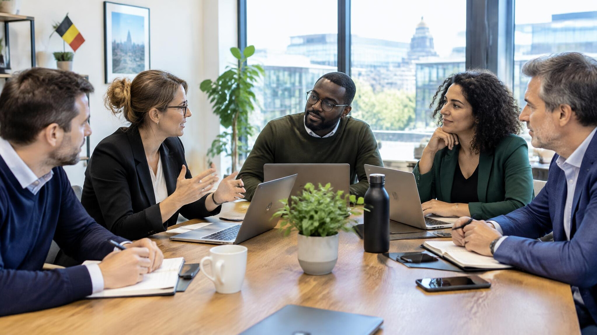 Diverse group of colleagues discussing around a table in a bright office